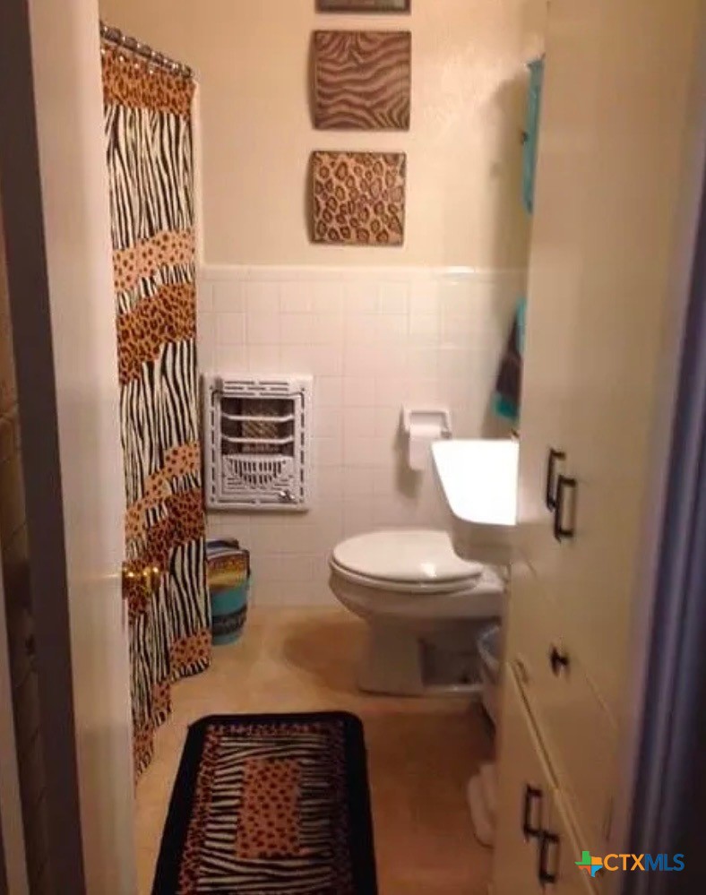 2418 Osage Road Gatesville, TX 76528 - Photo 9 of 15 a bathroom with a toilet a sink and mirror