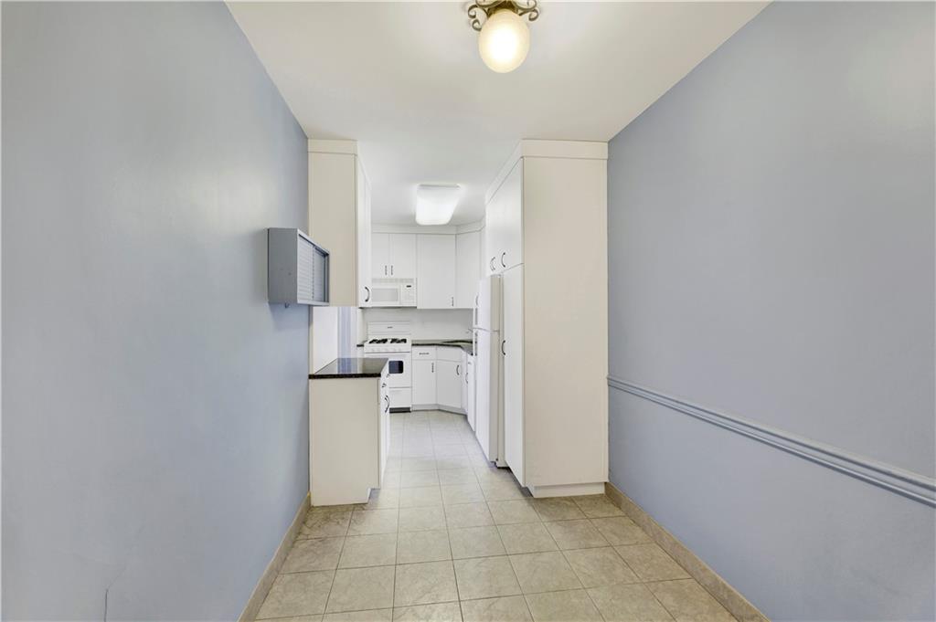 9902 3rd Avenue, Unit 1M Brooklyn, NY 11209 - Photo 14 of 20 a kitchen with a refrigerator and white cabinets