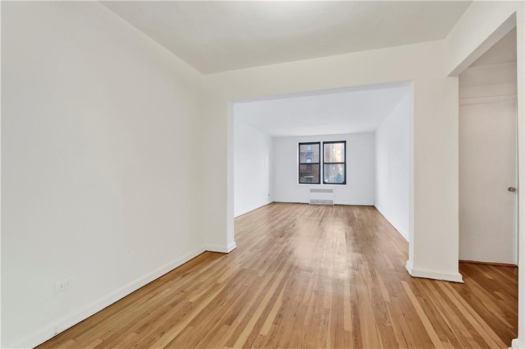 9902 3rd Avenue, Unit 1M Brooklyn, NY 11209 - Photo 4 of 20 an empty room with wooden floor and windows