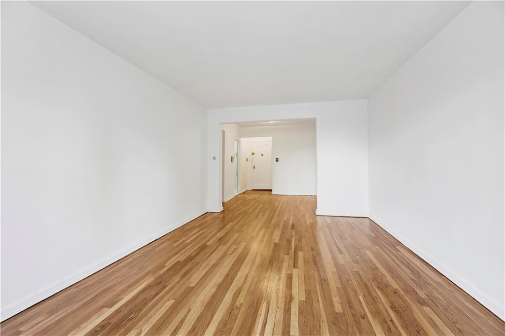9902 3rd Avenue, Unit 1M Brooklyn, NY 11209 - Photo 9 of 20 a view of a room with wooden floor and white walls