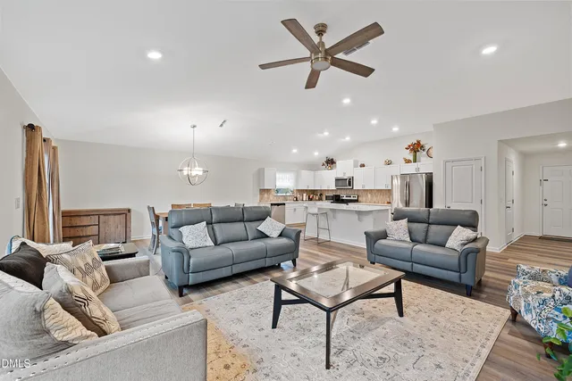 a living room with furniture and kitchen view