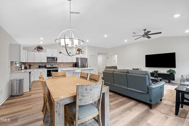 a living room with furniture a flat screen tv and kitchen view