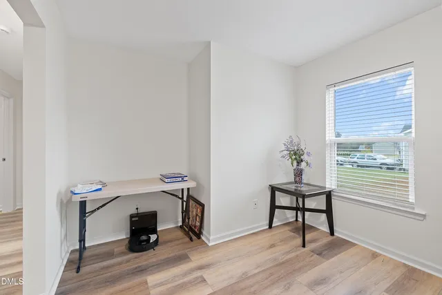 a view of a room that has a bench and a potted plant on the wooden floor
