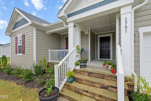 a view of a house with large windows and flower plants