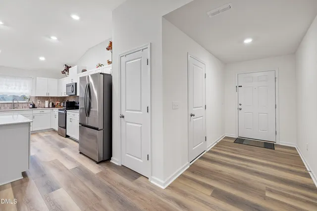 a view of kitchen with refrigerator and window