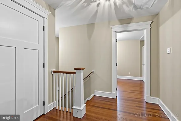 a view of a hallway with wooden floor and entryway