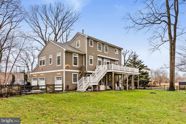 a view of a house with a big yard and large trees