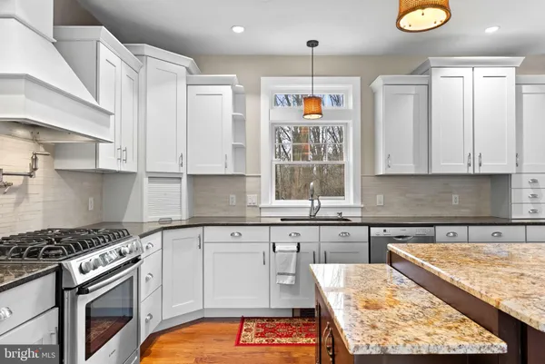 a kitchen with stainless steel appliances granite countertop a stove a sink and a microwave