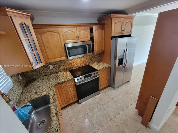 a kitchen with stainless steel appliances granite countertop a refrigerator a stove a sink and dishwasher
