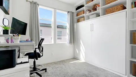 a view of a workspace with furniture and a window