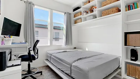 a bedroom with a bed and a flat tv screen on the table