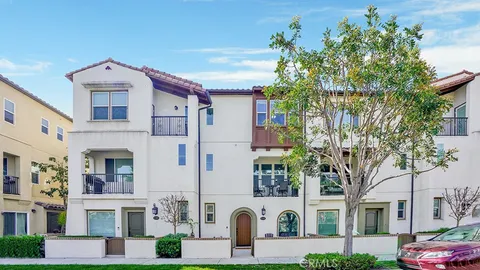 a front view of a residential apartment building with yard and parking