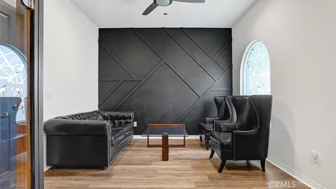 a hallway with chairs and a dresser with wooden floor