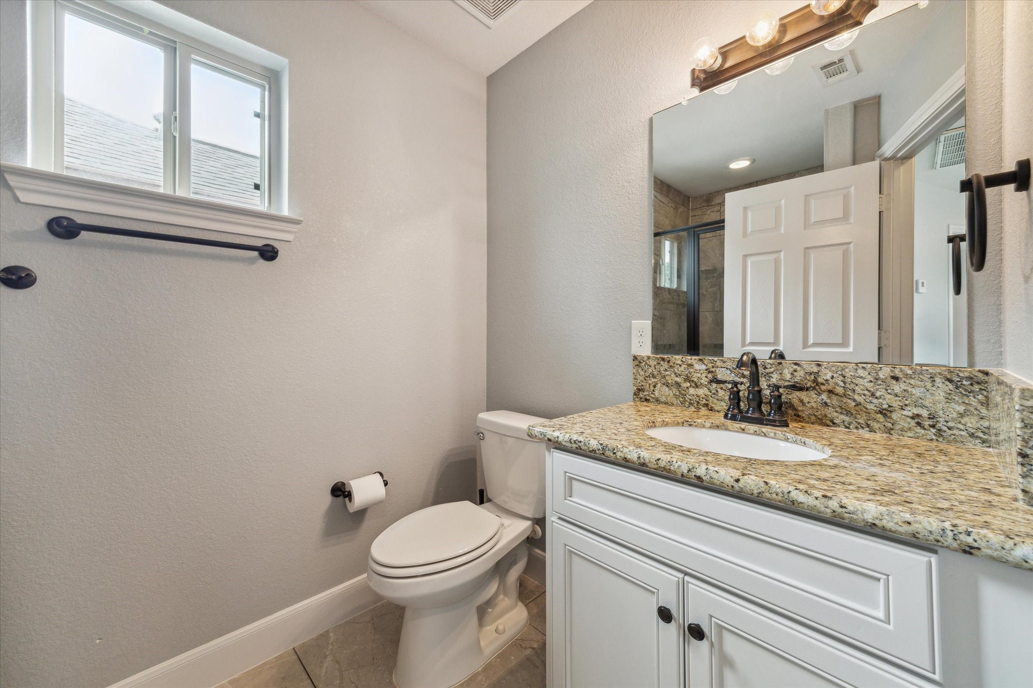 4916 Talina Way Houston, TX 77041 - Photo 13 of 25 a bathroom with a granite countertop toilet sink and mirror