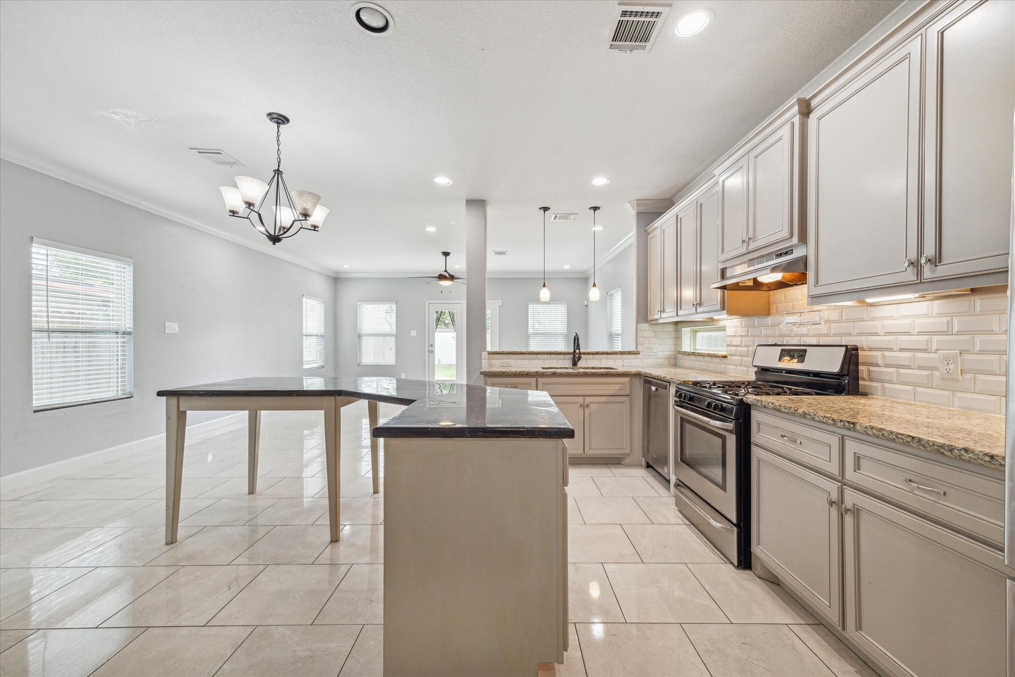 4916 Talina Way Houston, TX 77041 - Photo 3 of 25 a kitchen with kitchen island granite countertop a sink counter top space appliances and cabinets