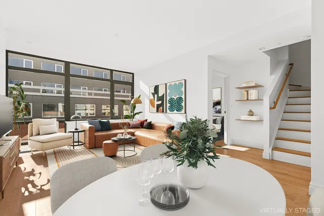 a living room with furniture large windows and wooden floor