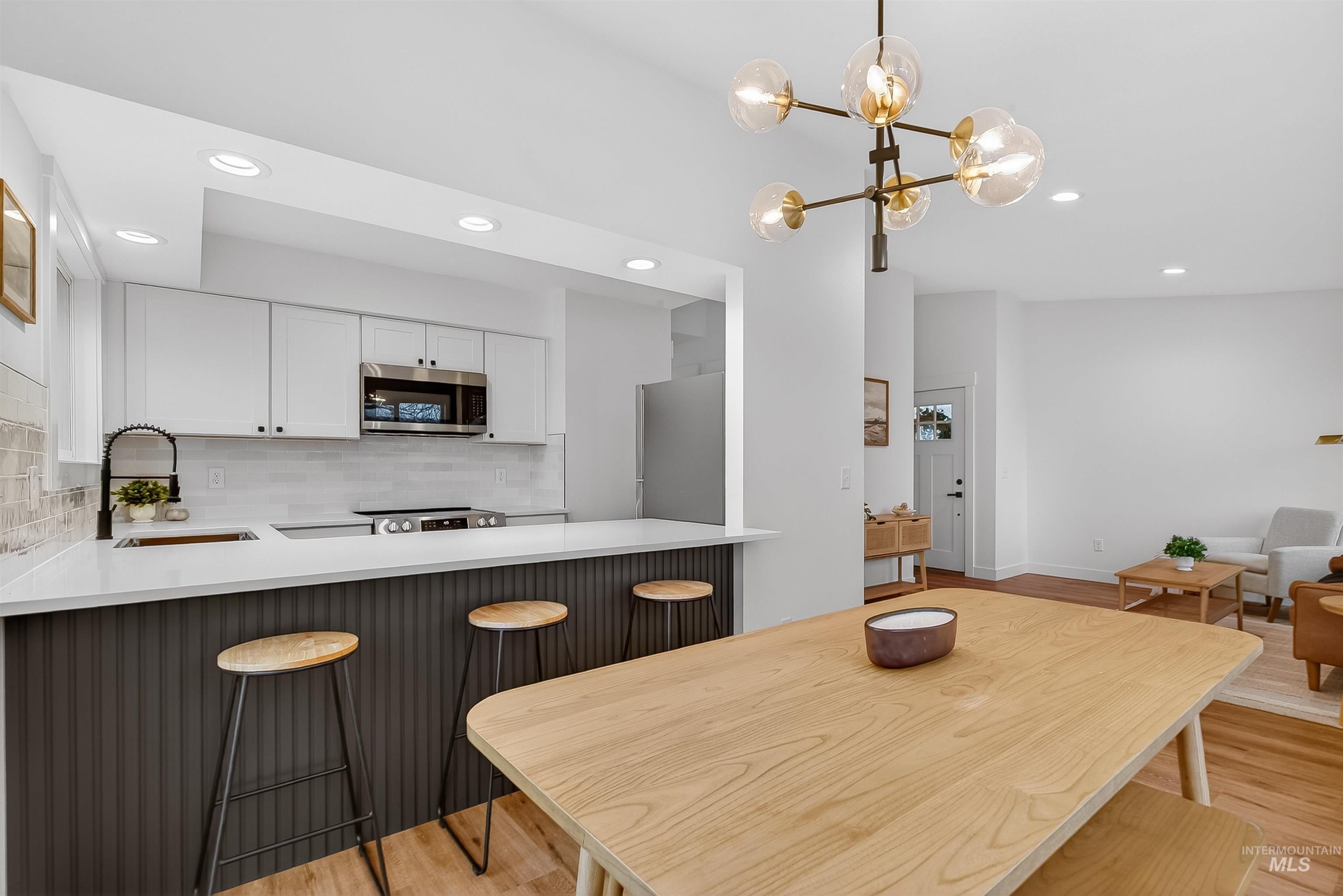 Dining room with recessed lighting, light wood-style floors, and a chandelier