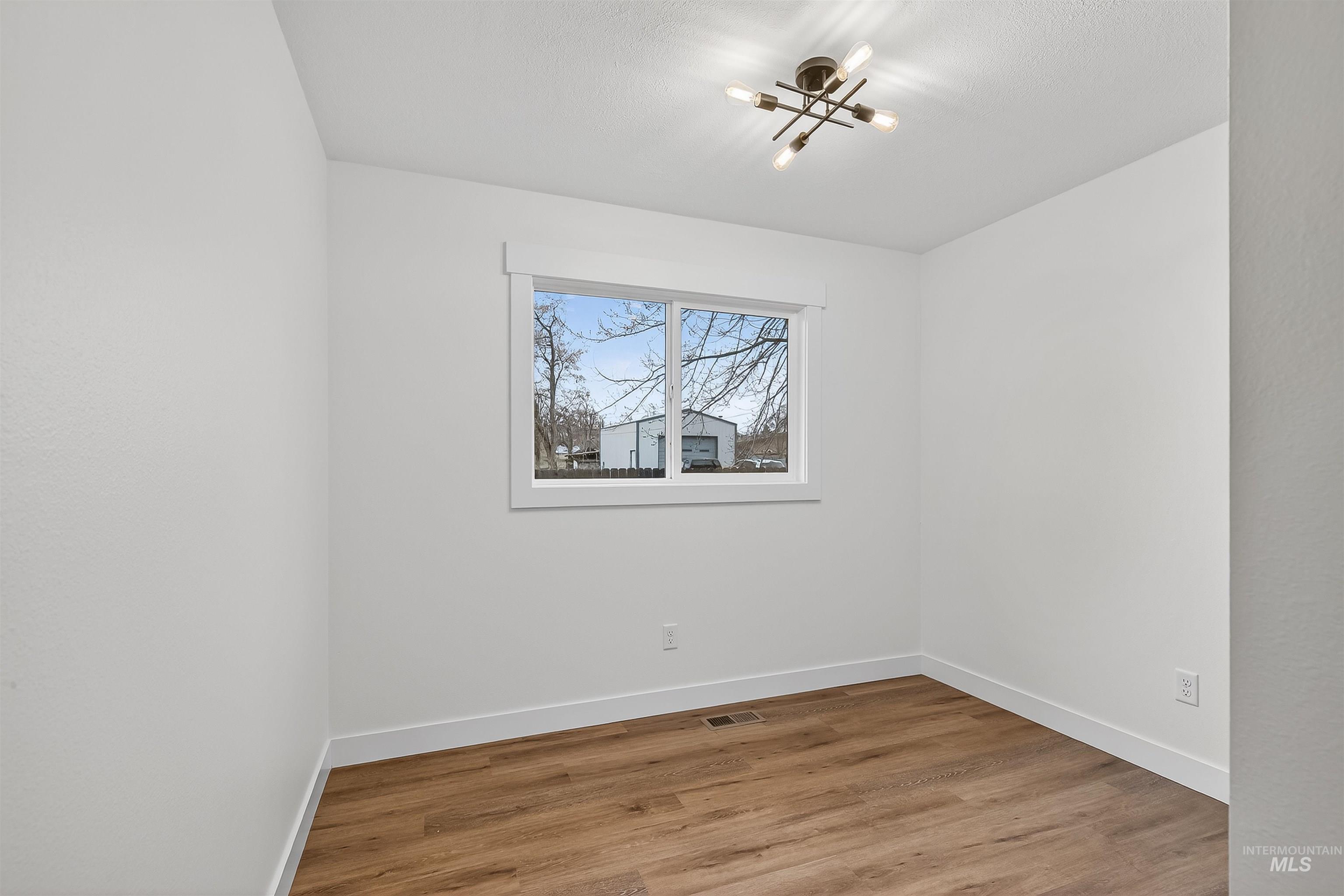 2922 Garfield Court Lewiston, ID 83501 - Photo 22 of 30 Unfurnished room featuring light wood-style flooring and a chandelier