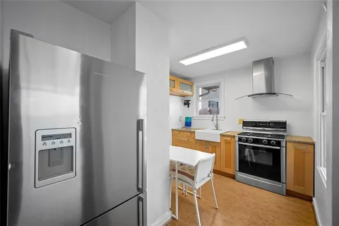 a kitchen with stainless steel appliances granite countertop a refrigerator and a stove top oven