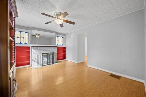 a view of empty room with fireplace and fan