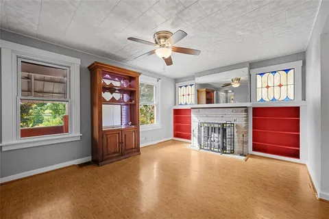 a view of an empty room with furniture and a window