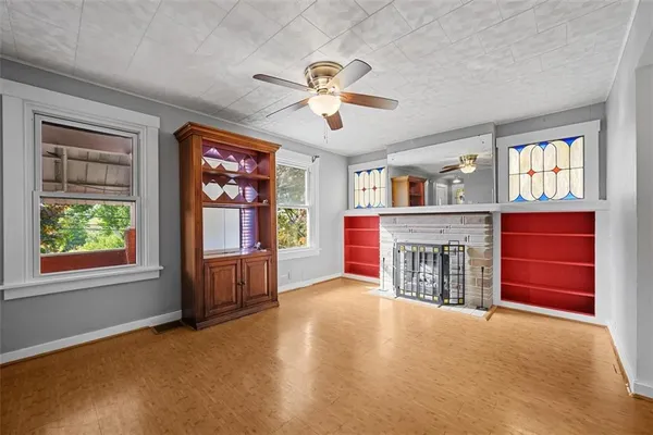a view of an empty room with furniture and a window