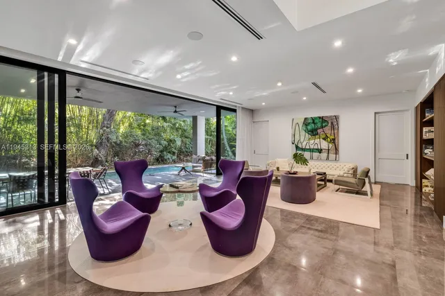 a living room with furniture and floor to ceiling windows