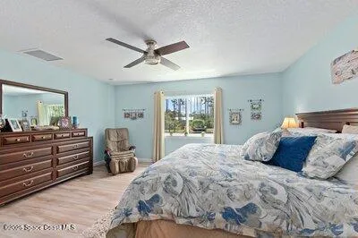 a spacious bathroom with a double vanity sink a mirror and next to a window