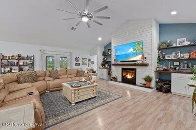 a large white kitchen with kitchen island a sink a counter top space and stainless steel appliances