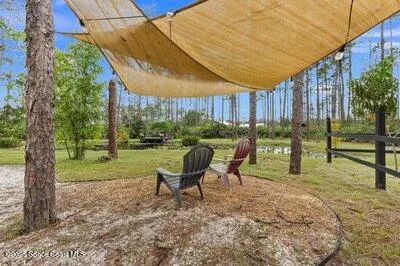 a view of a garden with a table and chairs under an umbrella