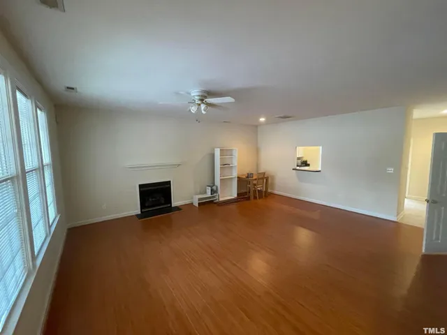 an empty room with windows and fireplace