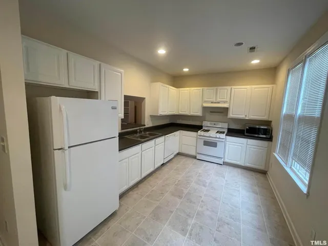 a kitchen with a refrigerator a sink and cabinets