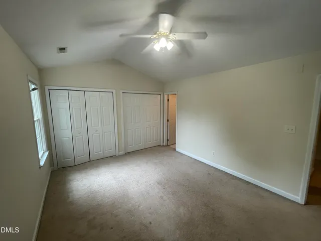 an empty room with a ceiling fan and a window
