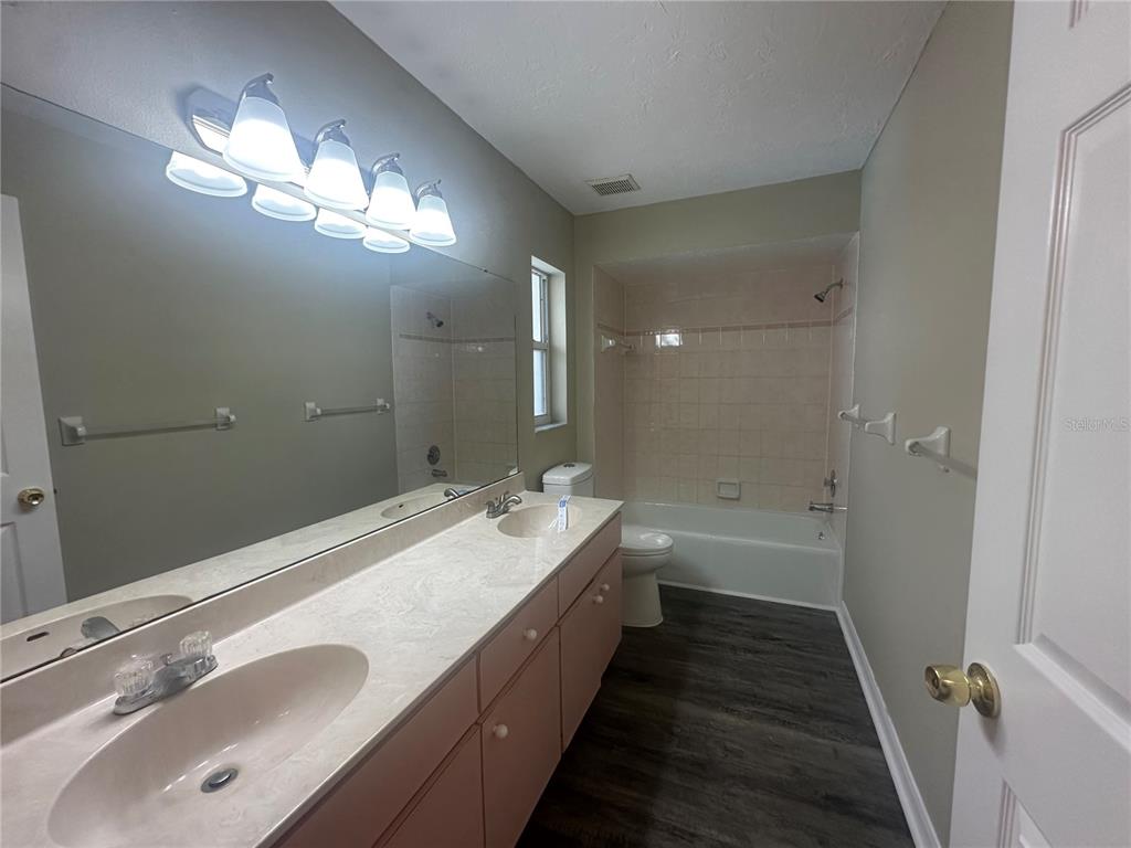 4495 Diamond Circle East Sarasota, FL 34233 - Photo 14 of 21 a bathroom with a double vanity sink a large mirror and shower