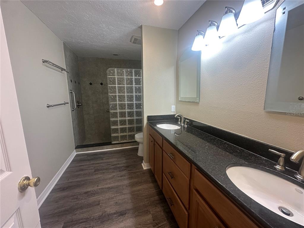 4495 Diamond Circle East Sarasota, FL 34233 - Photo 15 of 21 a bathroom with a double vanity sink a toilet a mirror and shower