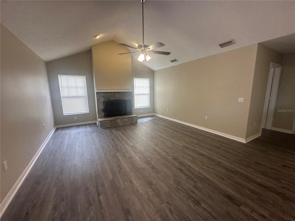 4495 Diamond Circle East Sarasota, FL 34233 - Photo 3 of 21 an empty room with wooden floor fireplace and windows