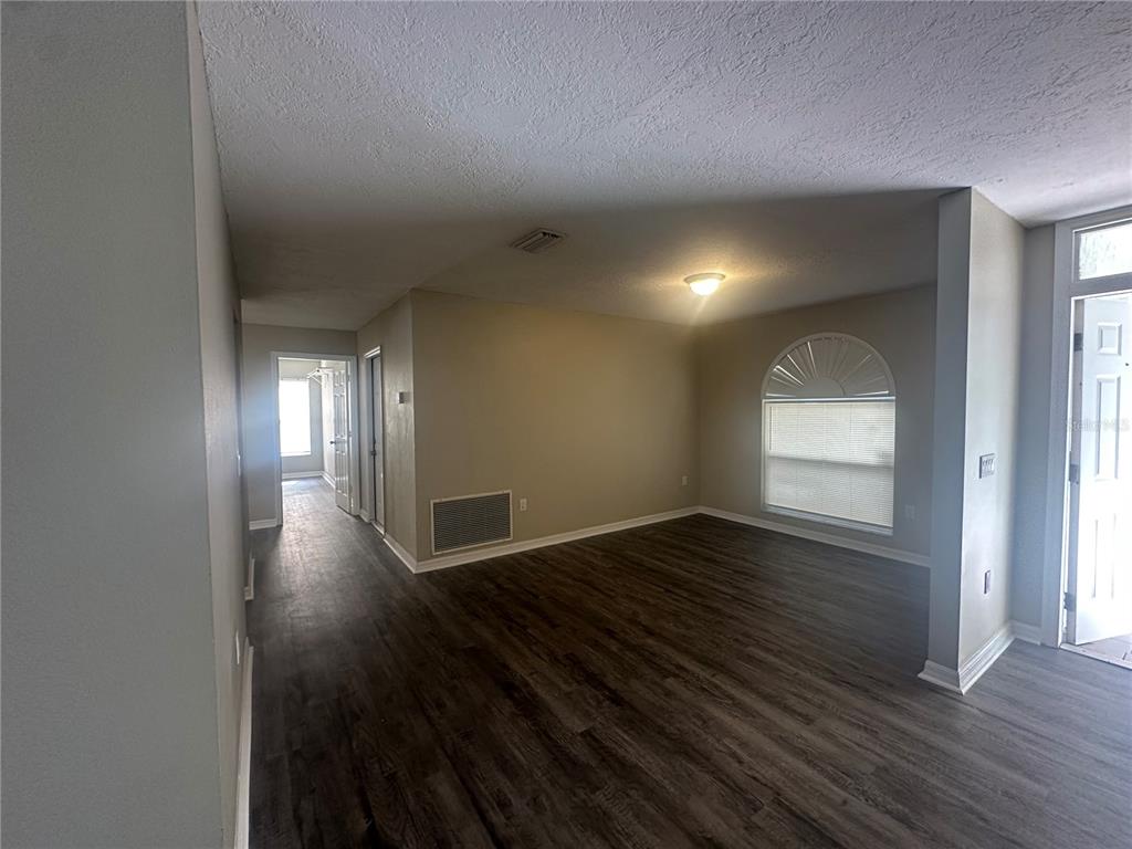 4495 Diamond Circle East Sarasota, FL 34233 - Photo 4 of 21 a view of an empty room with wooden floor and a window