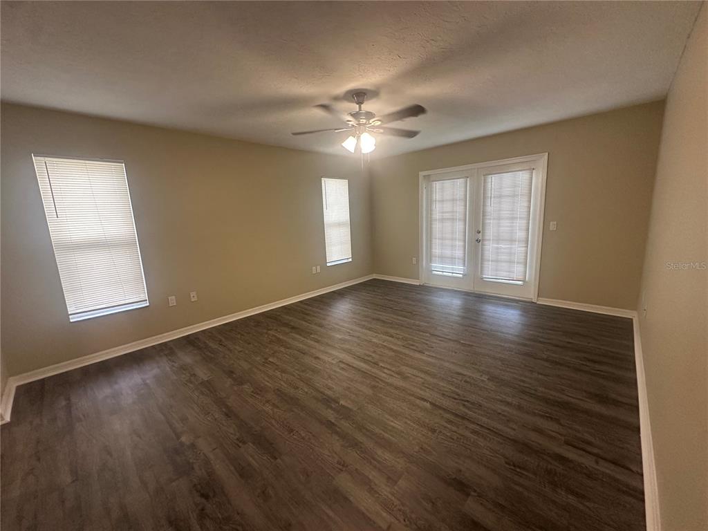 4495 Diamond Circle East Sarasota, FL 34233 - Photo 10 of 21 a view of an empty room with wooden floor and a window