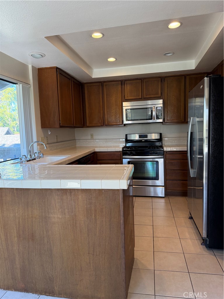 29 Cerrito Irvine, CA 92612 - Photo 4 of 11 a kitchen with stainless steel appliances granite countertop a stove a sink and a refrigerator