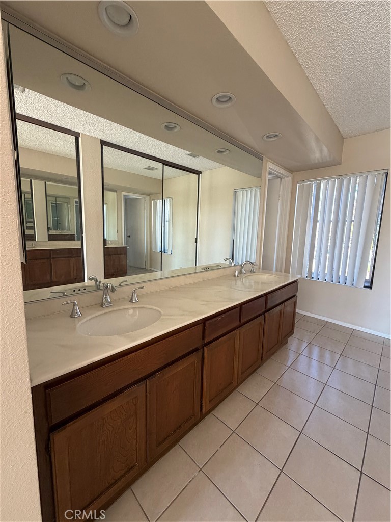 29 Cerrito Irvine, CA 92612 - Photo 7 of 11 a bathroom with a double vanity sink a mirror and a bathtub