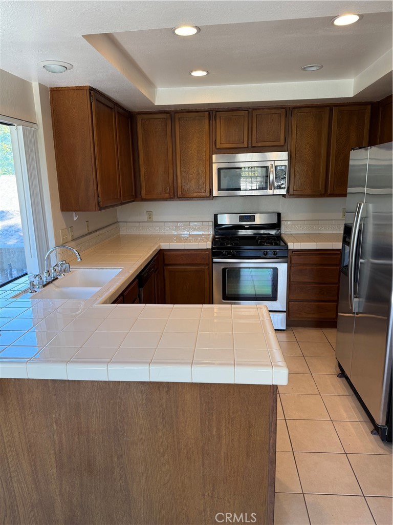 29 Cerrito Irvine, CA 92612 - Photo 10 of 11 a kitchen with granite countertop a refrigerator and a stove top oven