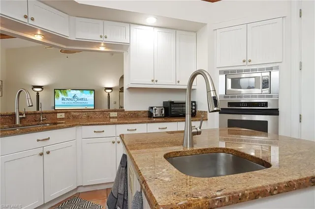 a kitchen with granite countertop a sink and cabinets
