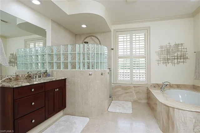 a bathroom with a tub sink and mirror