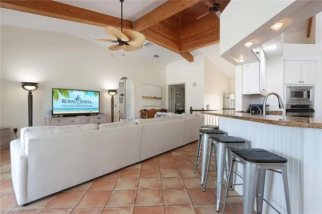 a living room with a table chairs and a kitchen view