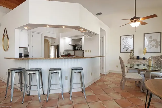 a kitchen with granite countertop white cabinets and chairs