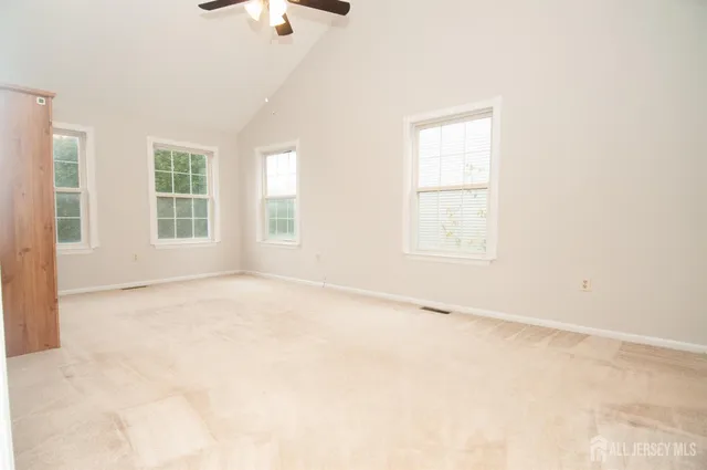 an empty room with windows and fan