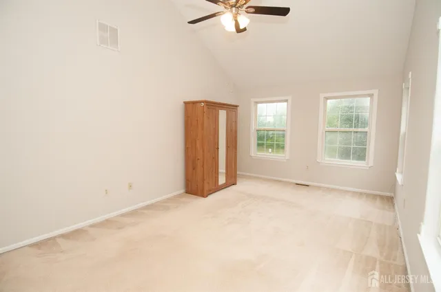 an empty room with windows and fan