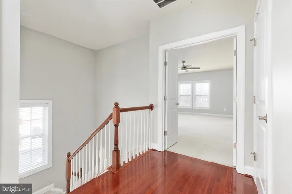 a view of a hallway with wooden floor and entryway