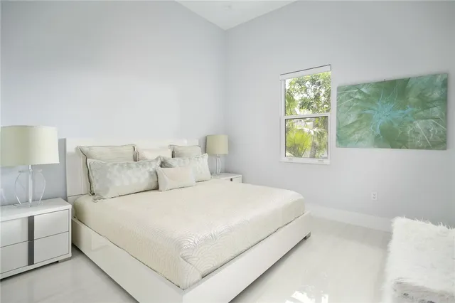 a bedroom with a bed and a lamp next to a window