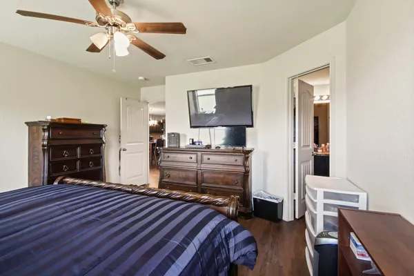 a bedroom with a bed and dresser with mirror